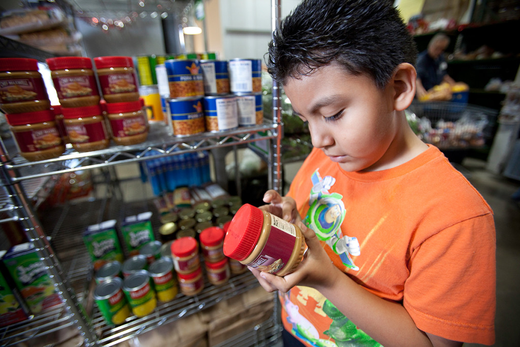 Desert-mission-food-bank-boy-reading-lable - HonorHealth Desert Mission